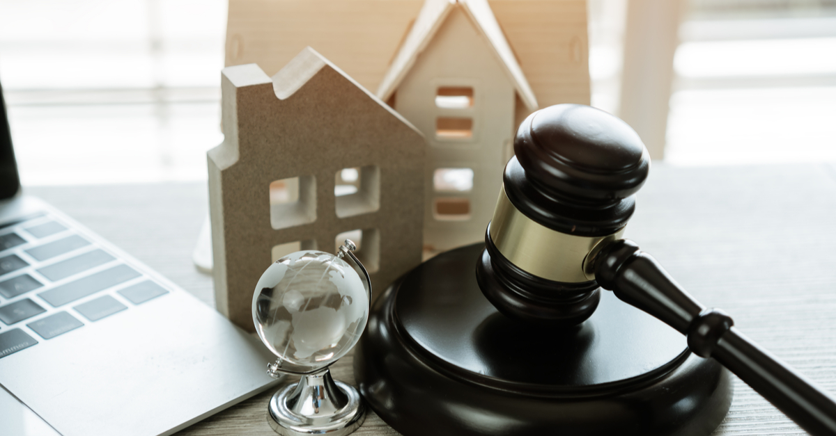 A gavel, a computer and mini houses in a lawyer office