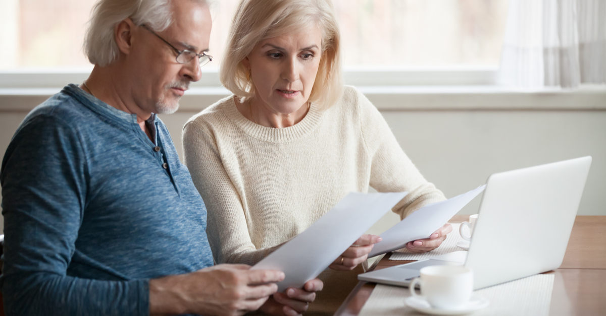 A worried couple looking at a mortgage payment document