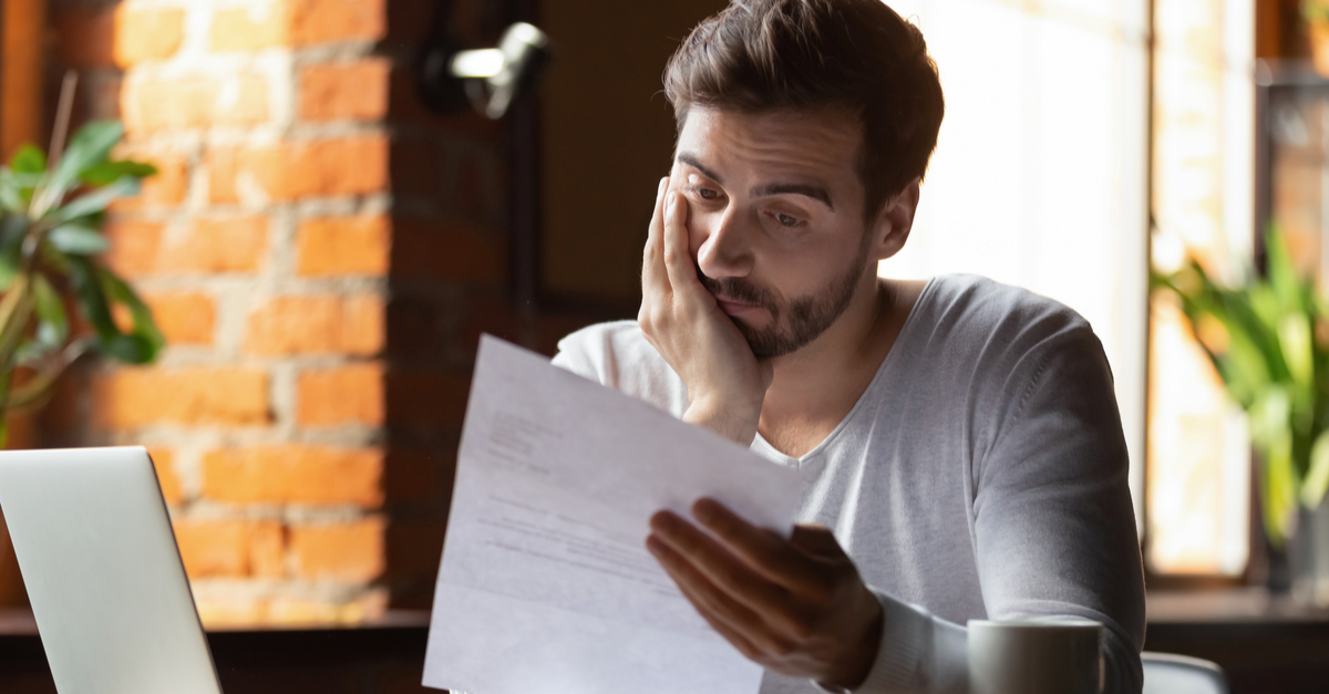 confused frustrated young man looking at debts