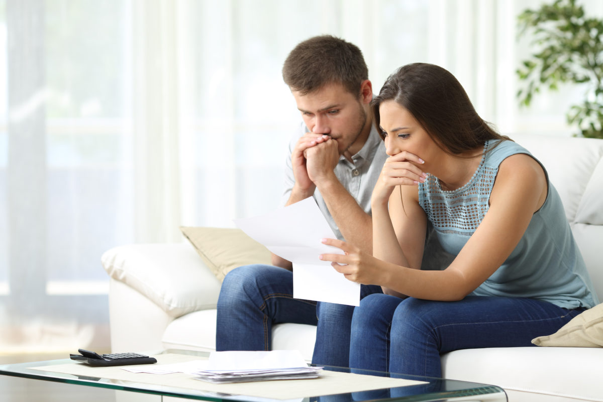 worried couple reading foreclosure notice