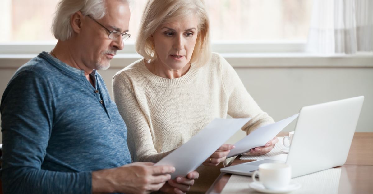 serious worried senior couple calculating bills