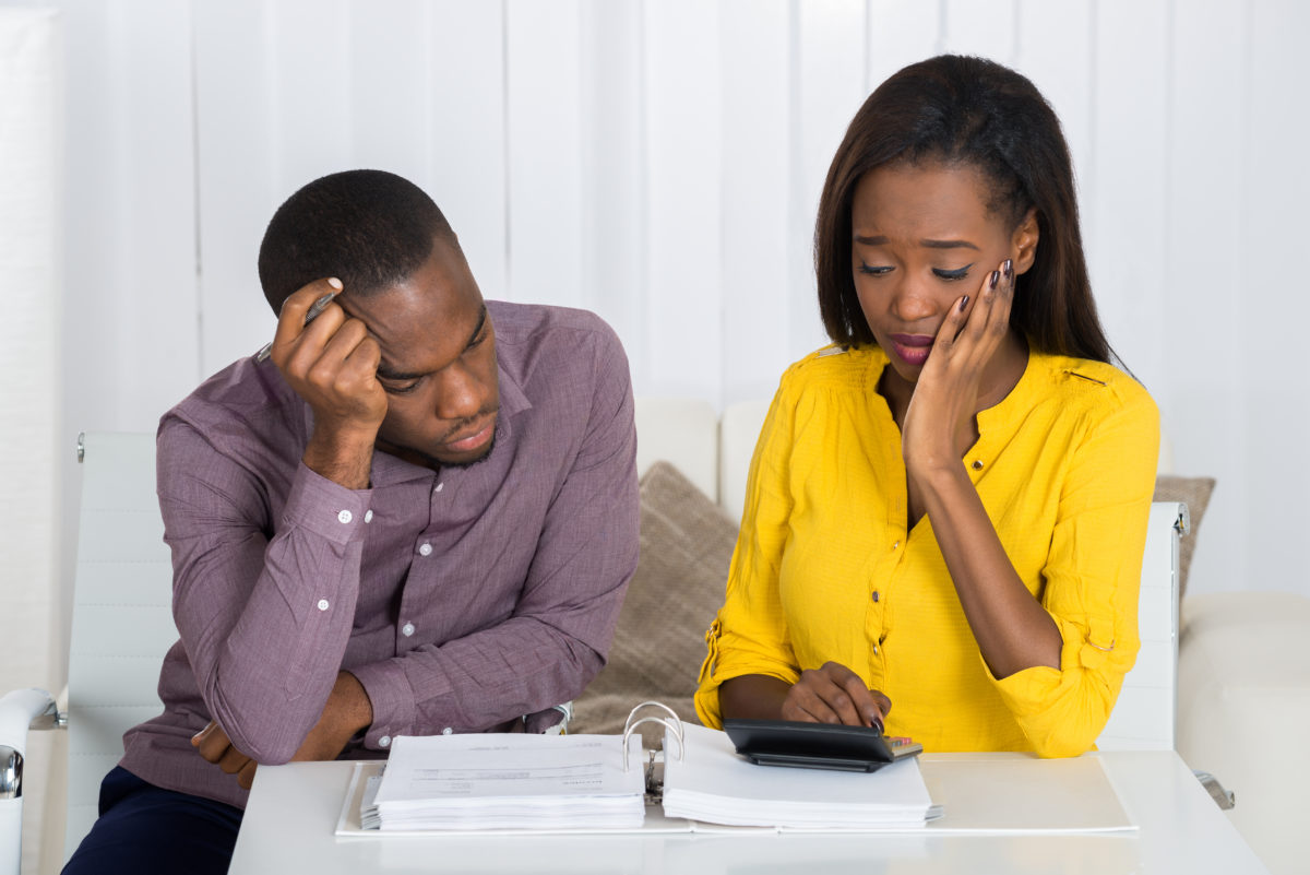 a couple reviewing their bank statements after a debt collector garnishes their wages
