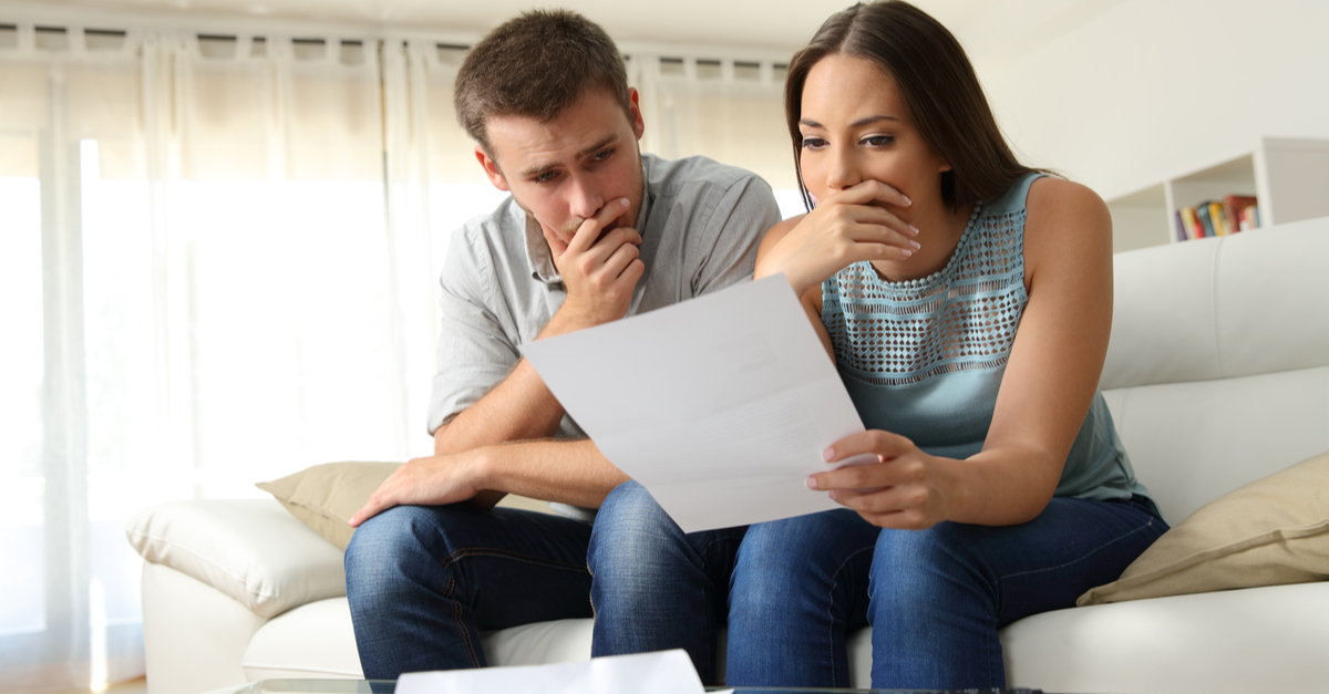 worried couple reading a foreclosure notice