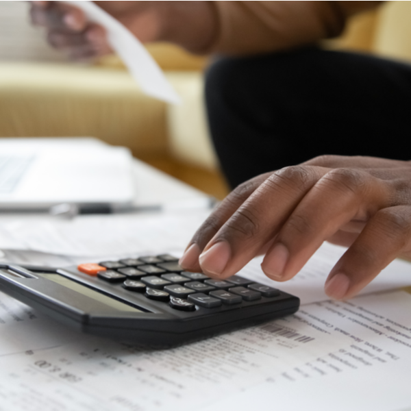 a man hand using calculator and laptop for calculating finance