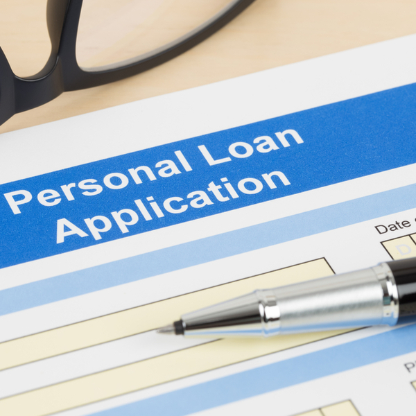 personal loan application form with glasses and a pen