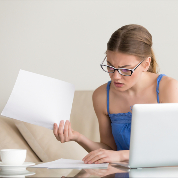 confused worried woman looks through debt collection letters