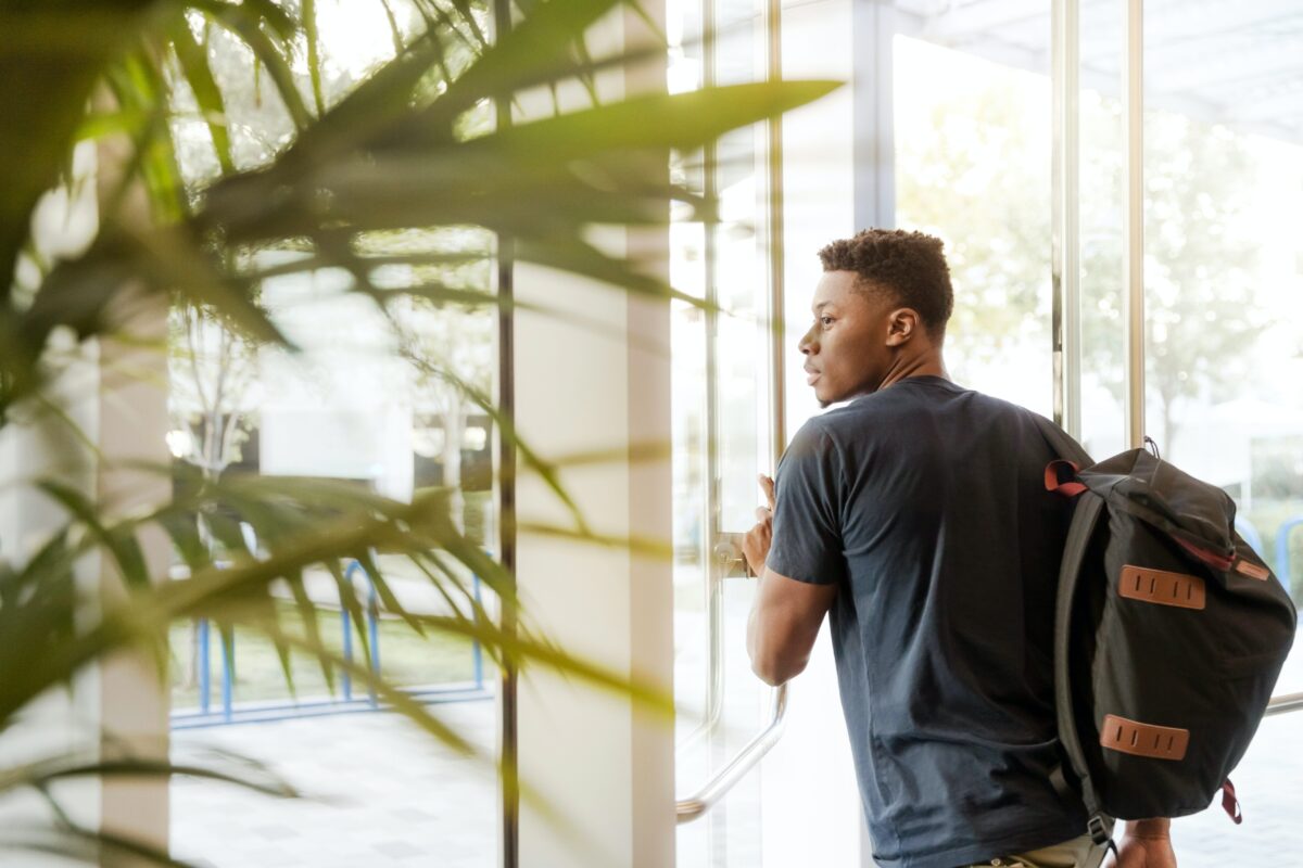 college student with loans walking out of a building