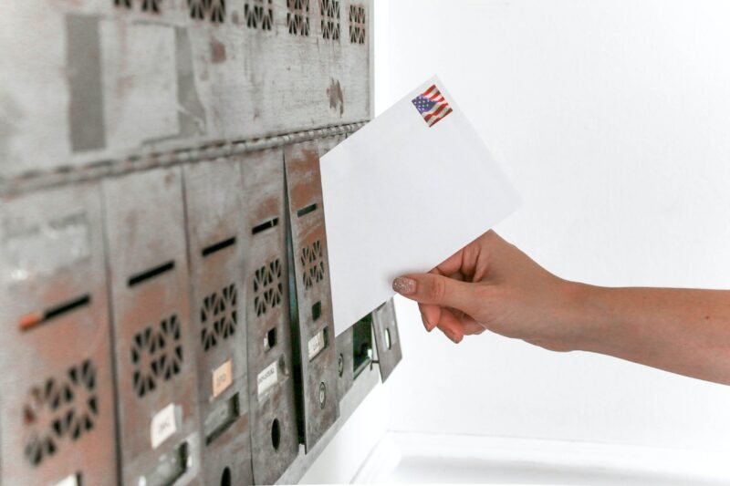 person putting a debt collection letter in a Florida mailbox