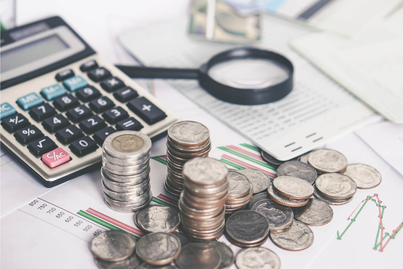 Calculator, coins, papers and magnifying glass representing debt