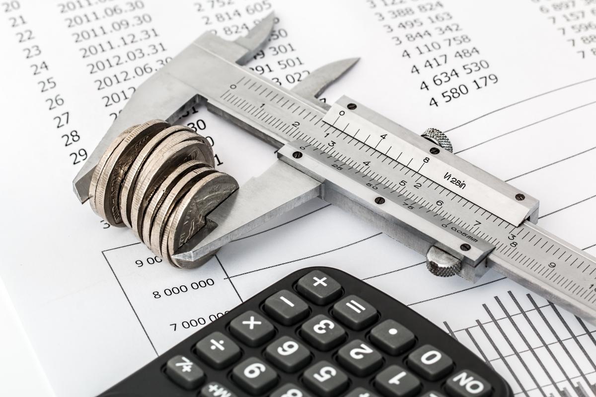 Coins and a calculator on top of a paper, representing debt